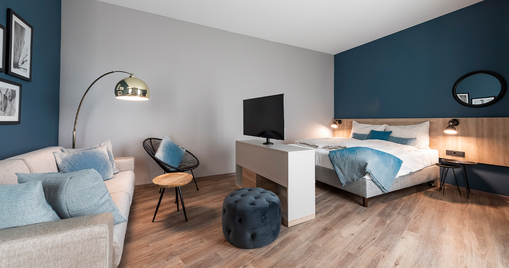 Hotelzimmer mit flexiblem TV-Board und Holz-Bettrückwand