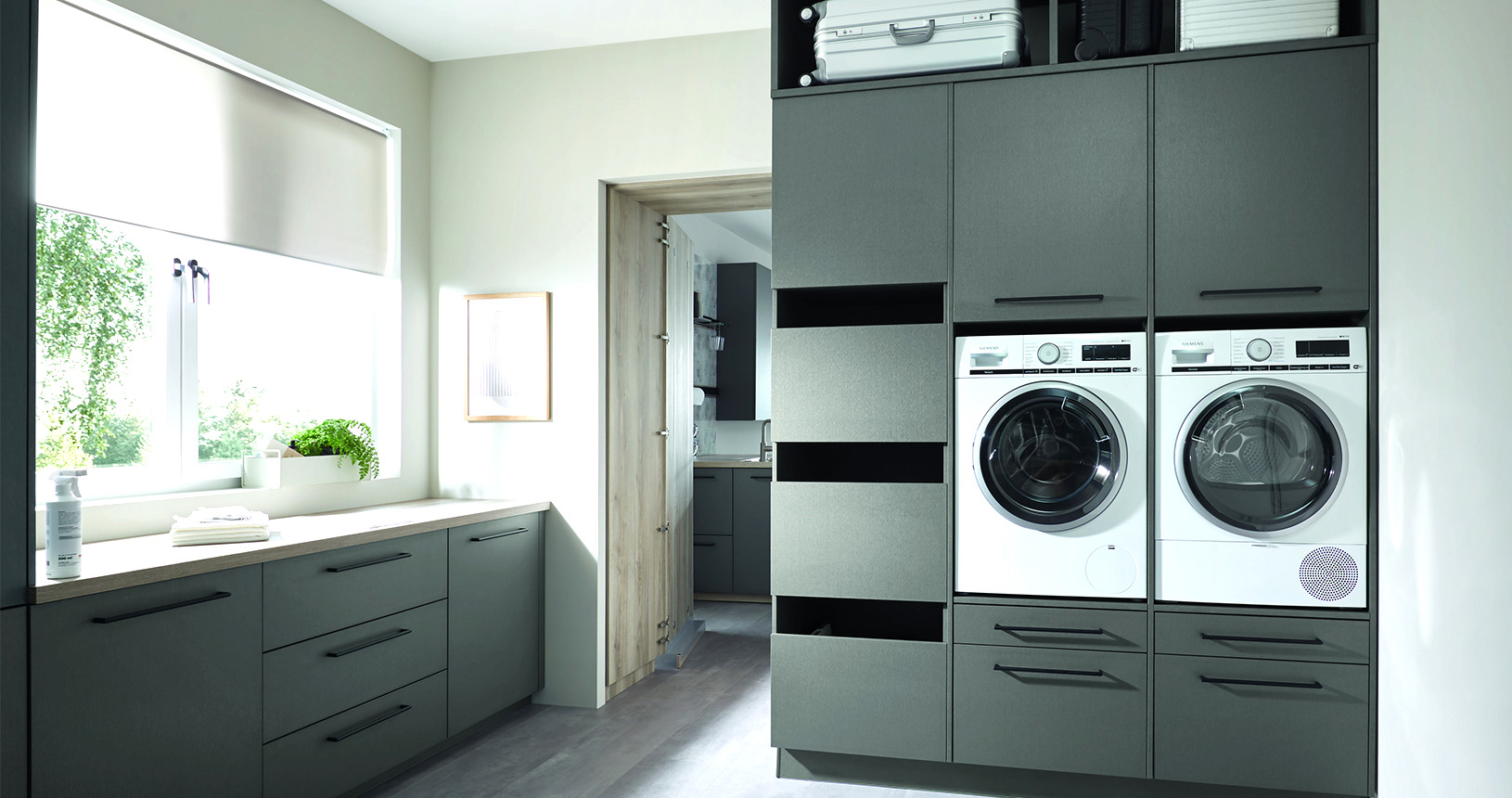 Hauswirtschaftsraum mit eingebauter Waschmaschine und Wäschetrockner