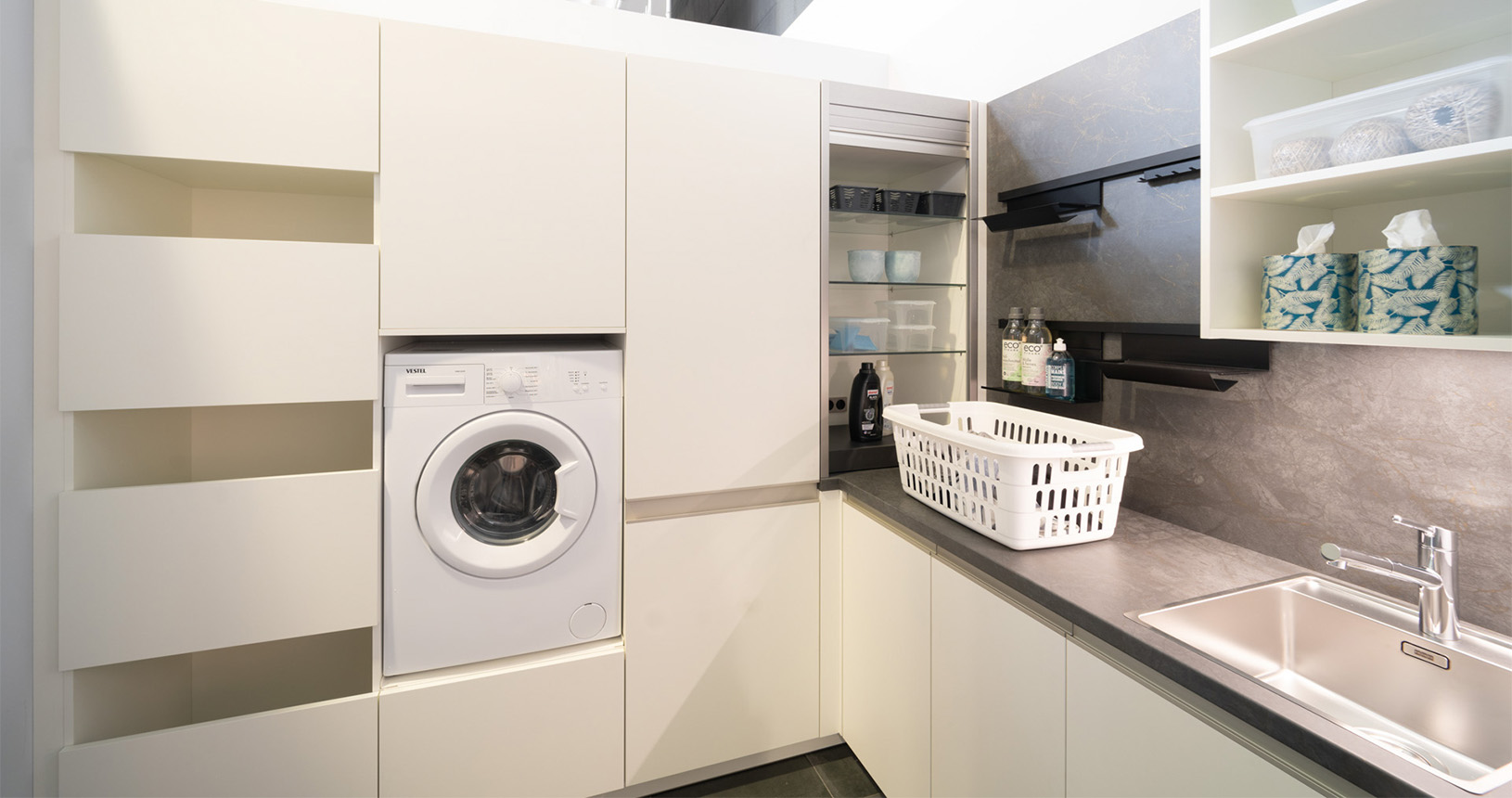 Hauswirtschaftsraum mit eingebauter Waschmaschine und Jalousieschrank