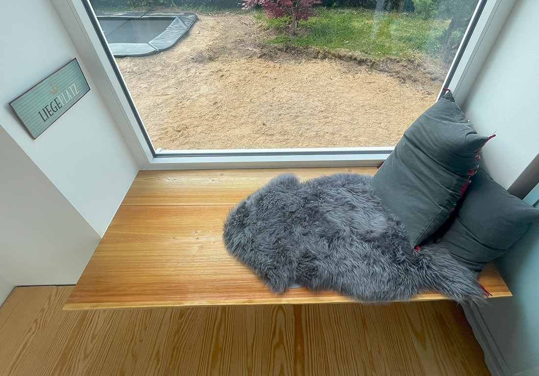 Sitzecke aus Massivholz an einer Fensterbank