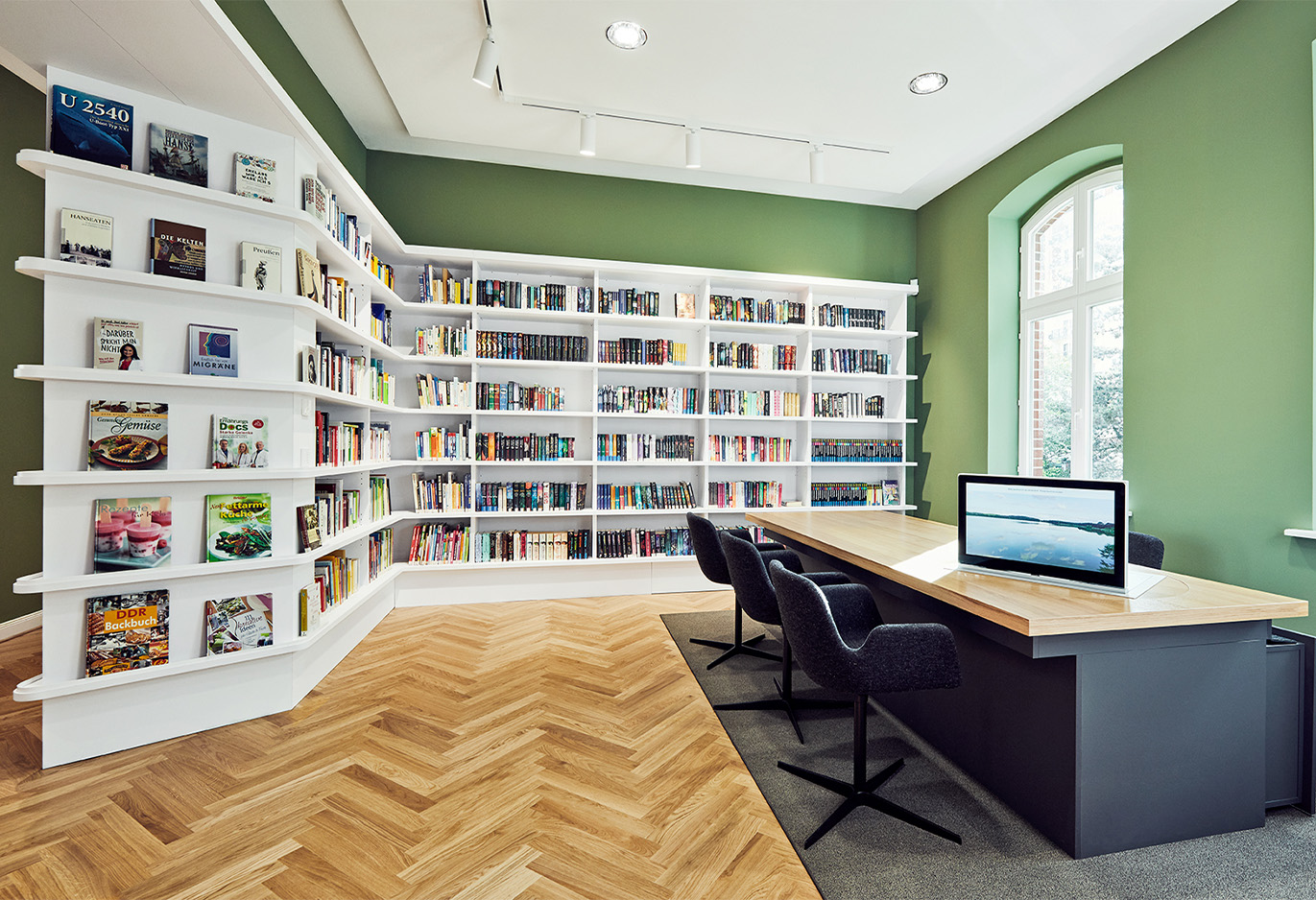 Bibliothek mit Regalsystemen und Schreibtischen mit Massivholz
